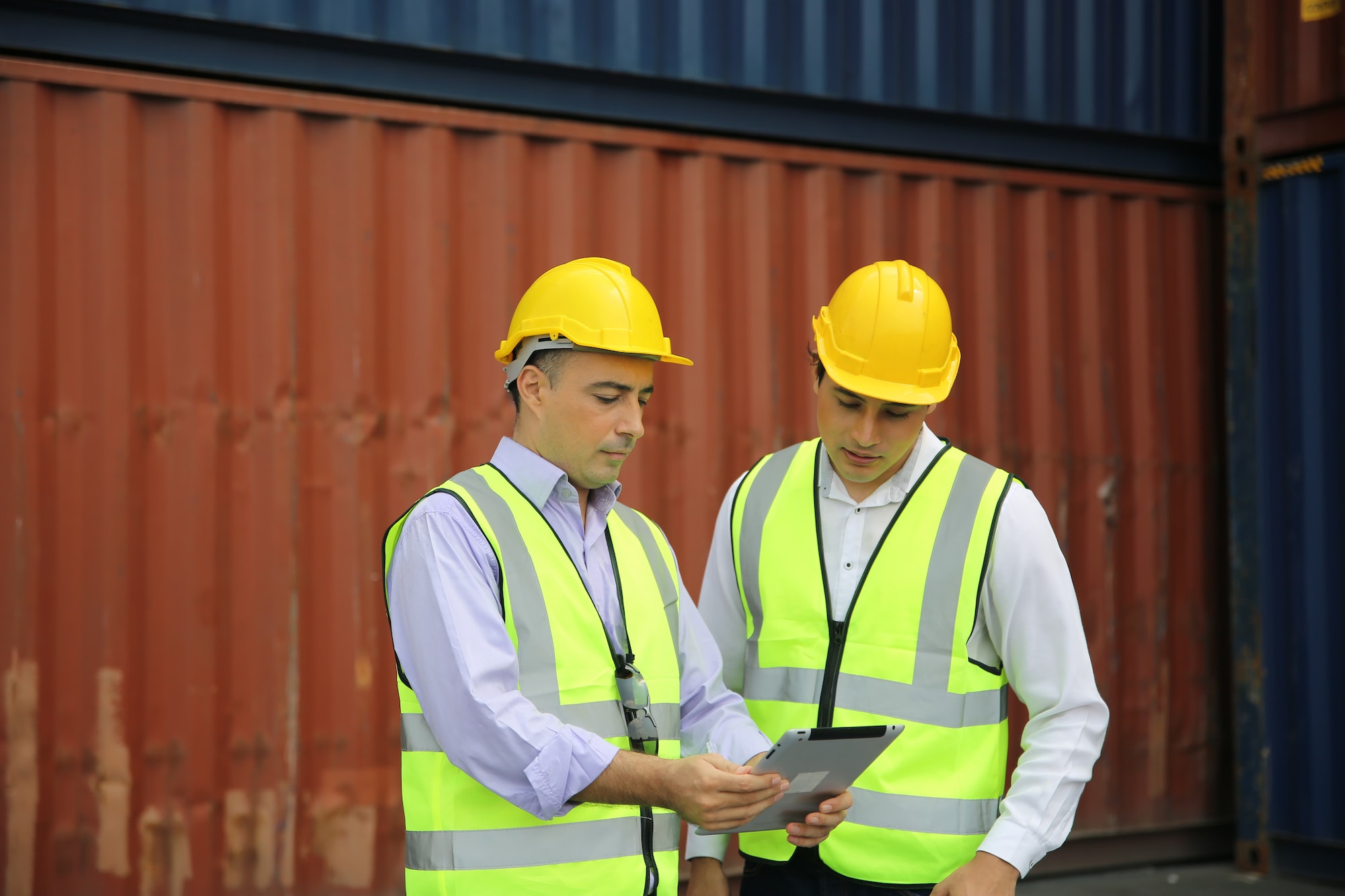 Logistics engineer control at the port, loading containers for trucks export and importing logistic
